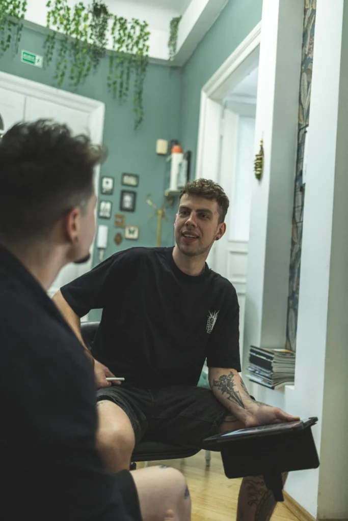 Tatuażysta wykonujący mały tatuaż na przedramieniu – przykładowy koszt tatuażu