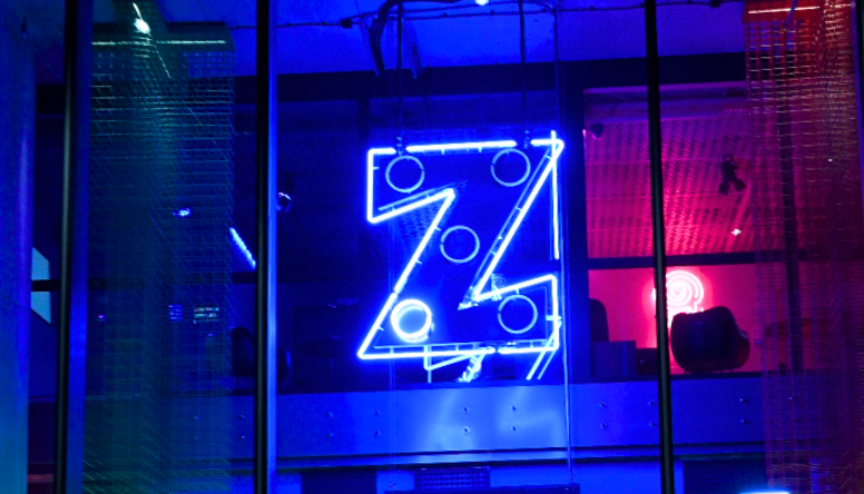 Niebieski neon z logo Zagrywki w Warszawie gdzie stoi automat tatuażowy